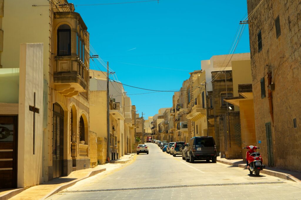 Tipična ulica v Omanu z arabsko arhitekturo, pisanimi fasadami in lokalnim utripom mestnega življenja.