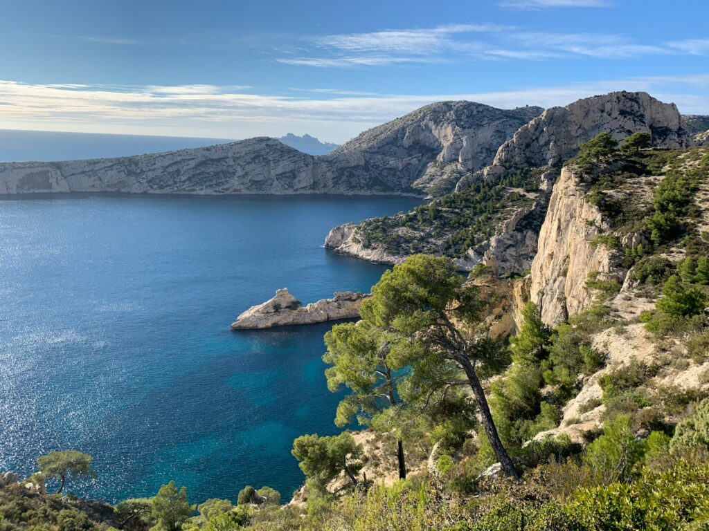 Osupljiv razgled na skalnato obalo Calanques pri Marseillu z modrim morjem in sredozemskim rastlinjem.