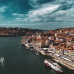 Porto: Skrivni kotički, ki jih domačini nikoli ne razkrijejo turistom Pogled na Porto in reko Douro z ladjicami ter barvitimi hišami ob obali.
